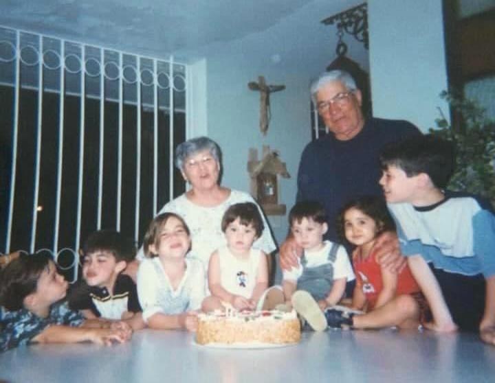 Familia reunida alrededor de un bizcocho de cumpleaños